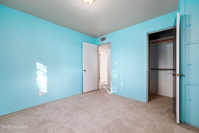 unfurnished bedroom with light colored carpet and a closet