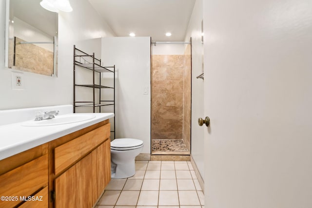 bathroom featuring vanity, toilet, tile patterned flooring, and a tile shower