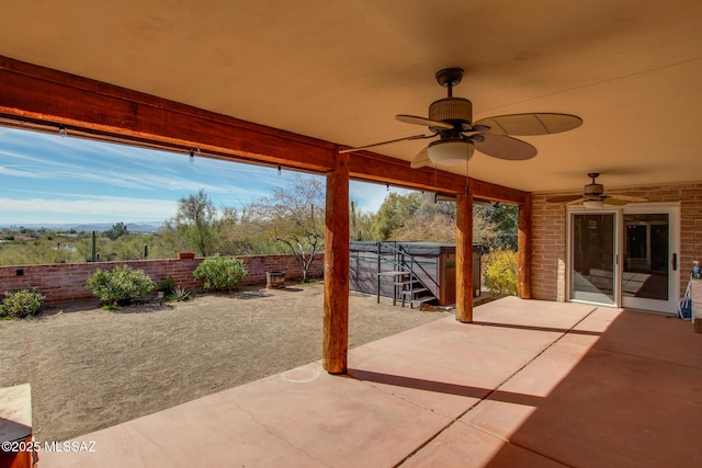 view of patio featuring ceiling fan and a hot tub