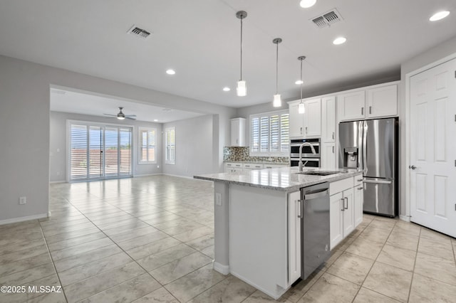 8270 W Spaulding St, Tucson, AZ 85743 - kitchen featuring appliances with stainless steel finishes, recessed lighting, baseboards, tasteful backsplash, and an island with sink