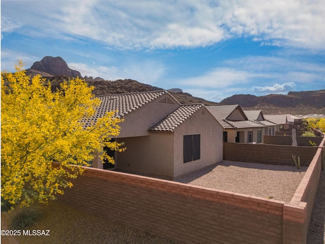 8270 W Spaulding St, Tucson, AZ 85743 - rear view of property featuring a mountain view, a fenced backyard, stucco siding, a tile roof, and a patio area