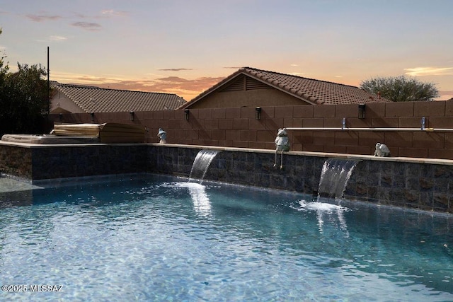 pool at dusk with pool water feature