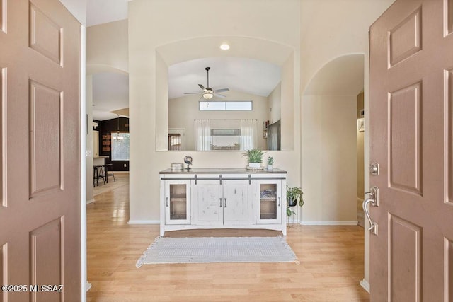 foyer entrance featuring ceiling fan, high vaulted ceiling, and light hardwood / wood-style flooring