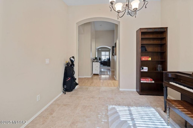 hall with a notable chandelier and light tile patterned flooring