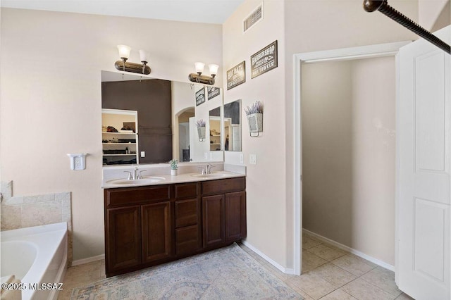 bathroom featuring tile patterned flooring, vanity, and a bathtub