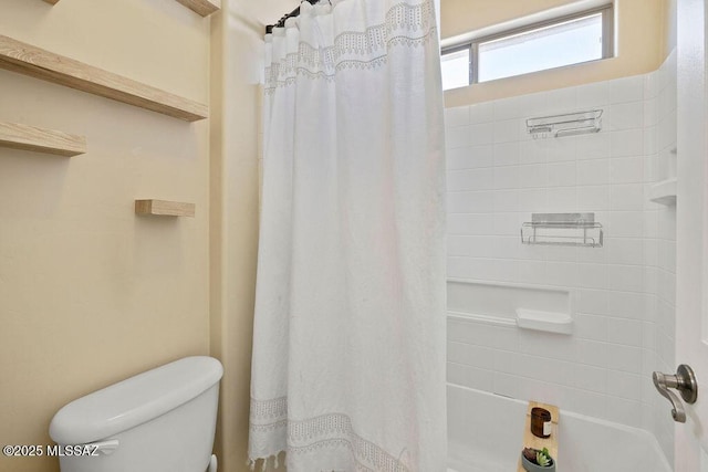 bathroom featuring shower / bath combination with curtain and toilet