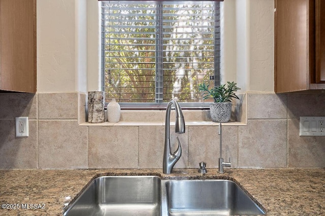 kitchen featuring stone counters, sink, and decorative backsplash