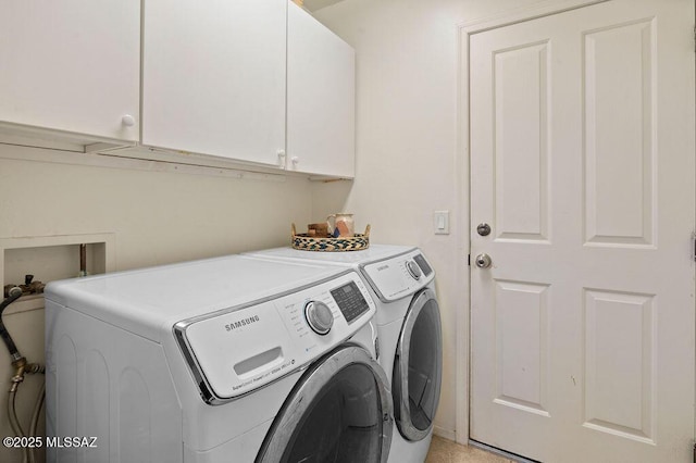 laundry area with cabinets and washing machine and clothes dryer