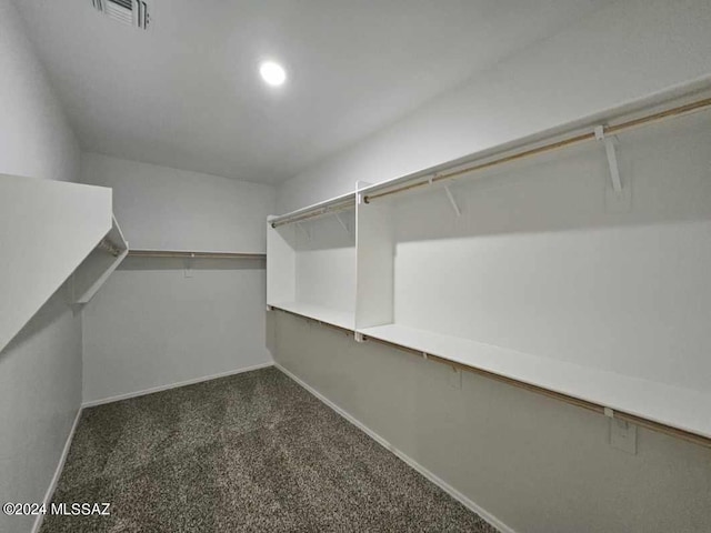 spacious closet featuring dark carpet