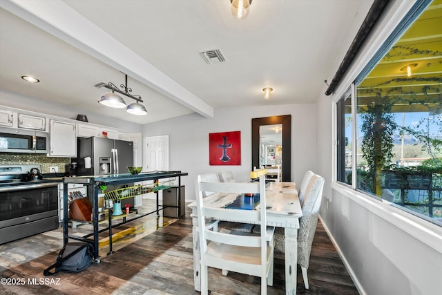 dining room with dark wood-type flooring and beam ceiling