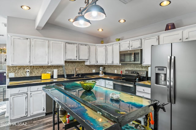 kitchen with sink, tasteful backsplash, hanging light fixtures, stainless steel appliances, and white cabinets