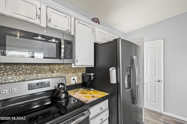 kitchen featuring white cabinetry, decorative backsplash, dark hardwood / wood-style flooring, and stainless steel appliances