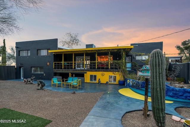 back house at dusk featuring a patio