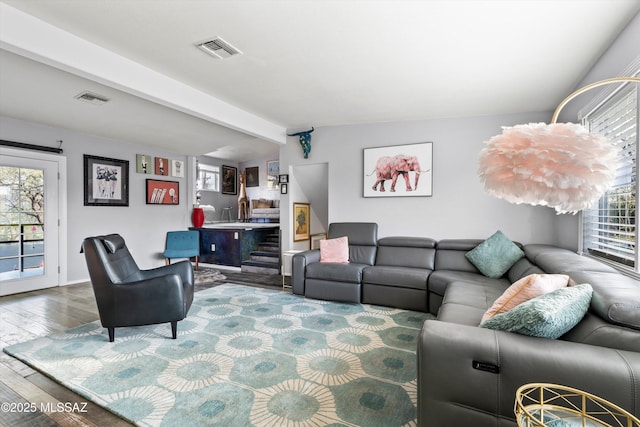 living room with hardwood / wood-style floors and vaulted ceiling with beams