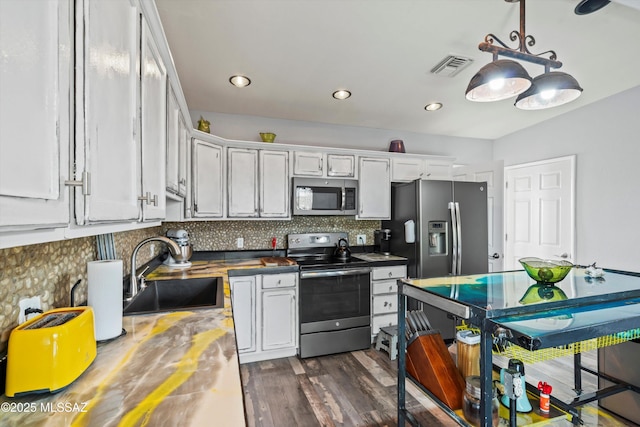 4502 N Twilight Trl, Tucson, AZ 85749 - kitchen with stainless steel appliances, a sink, dark wood finished floors, tasteful backsplash, and white cabinetry