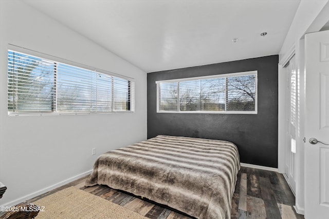 bedroom with lofted ceiling, hardwood / wood-style flooring, and multiple windows