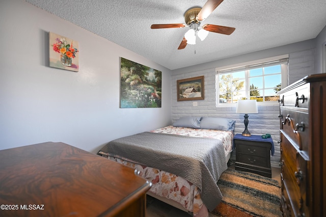 bedroom with ceiling fan and a textured ceiling