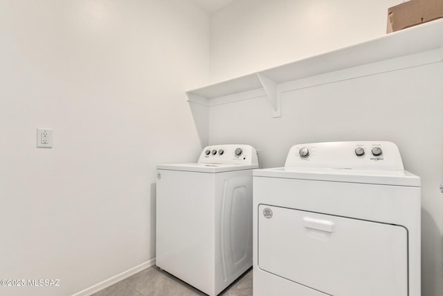 laundry area featuring light tile patterned floors and washing machine and dryer