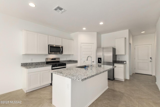 kitchen featuring stainless steel appliances, sink, a kitchen island with sink, and white cabinets