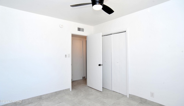 unfurnished bedroom with ceiling fan and a closet