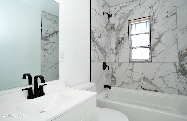 full bathroom featuring tiled shower / bath, vanity, and toilet