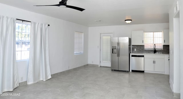 kitchen featuring stainless steel appliances, sink, decorative backsplash, and white cabinets