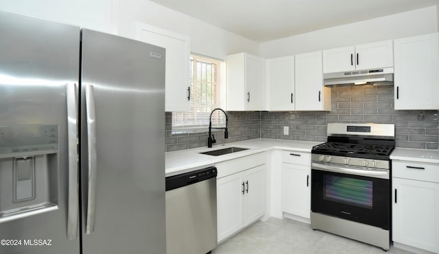 kitchen featuring sink, white cabinets, decorative backsplash, light tile patterned floors, and stainless steel appliances