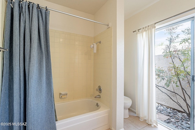 full bath with shower / tub combo, tile patterned flooring, and toilet