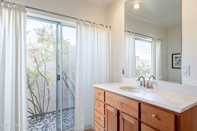 bathroom featuring a textured wall and vanity