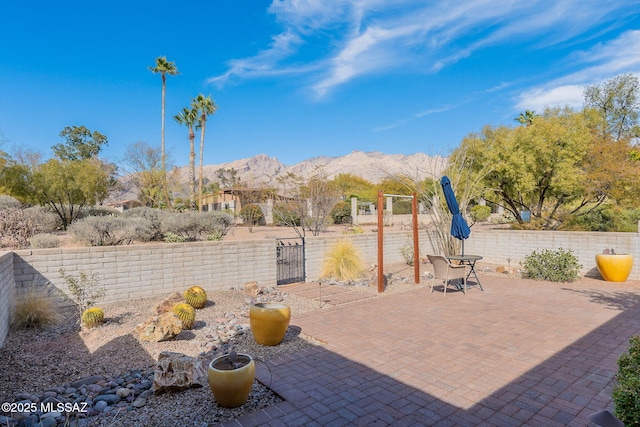 view of patio with a gate, fence, and a mountain view