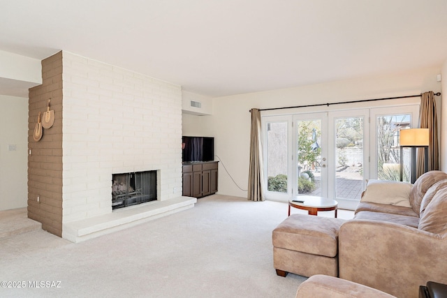 carpeted living area with visible vents and a fireplace