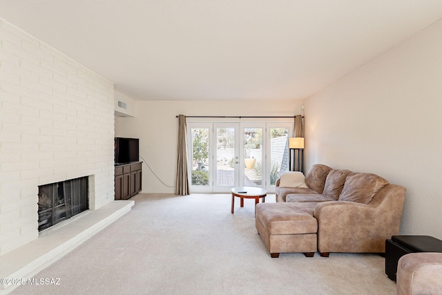 living room featuring light carpet, french doors, a fireplace, and visible vents