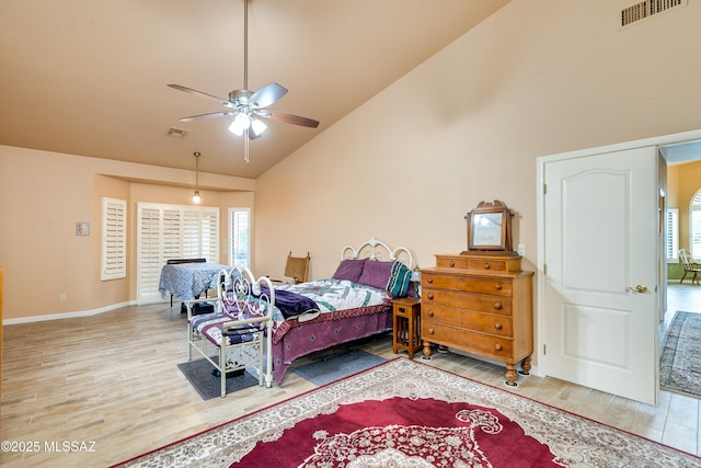 bedroom featuring high vaulted ceiling, hardwood / wood-style flooring, ceiling fan, and multiple windows