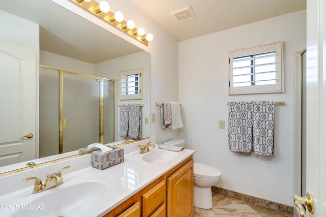bathroom featuring toilet, a shower with door, and vanity