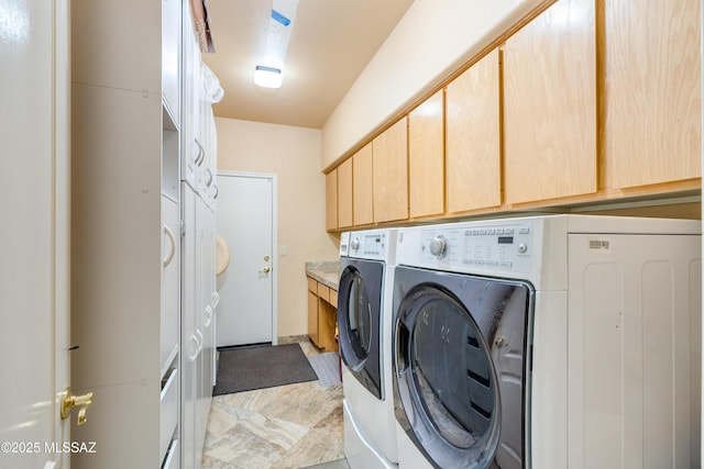 laundry room with washing machine and dryer and cabinets