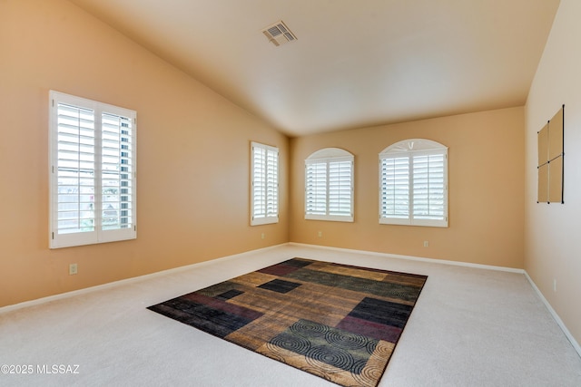 carpeted empty room featuring vaulted ceiling