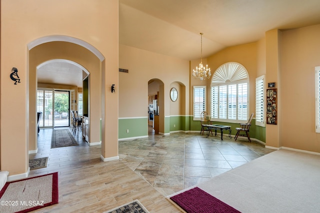 entrance foyer with a notable chandelier and lofted ceiling