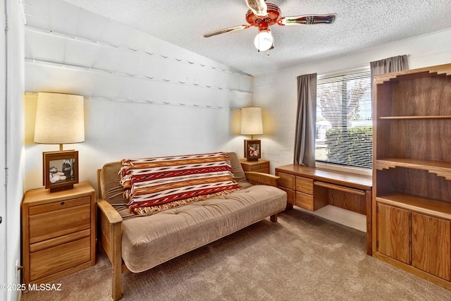 sitting room with built in desk, light colored carpet, vaulted ceiling, a textured ceiling, and ceiling fan