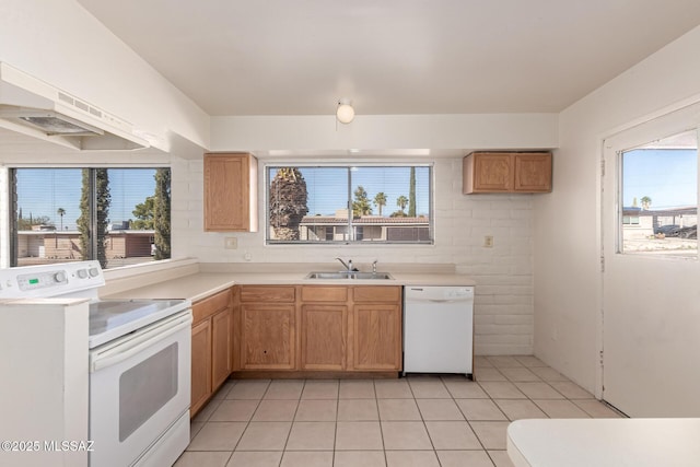 kitchen featuring light tile patterned flooring, sink, and white appliances