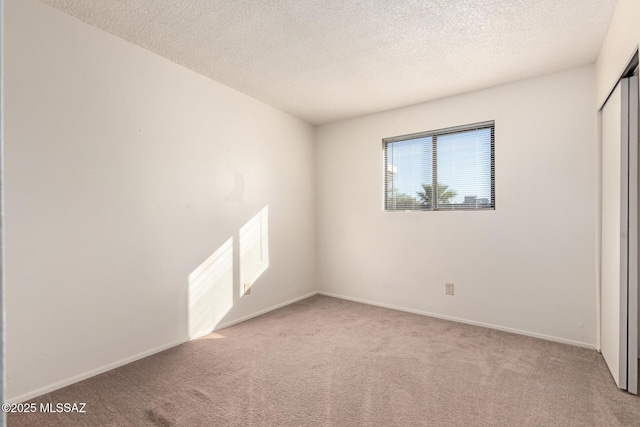 empty room featuring light carpet and a textured ceiling