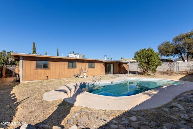 back of house with a fenced in pool and a patio area