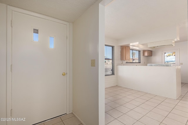 foyer featuring a textured ceiling and light tile patterned floors