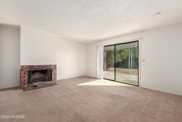 unfurnished living room featuring a brick fireplace, light carpet, and a textured ceiling