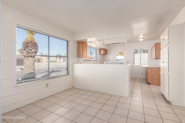 kitchen with light tile patterned flooring and kitchen peninsula