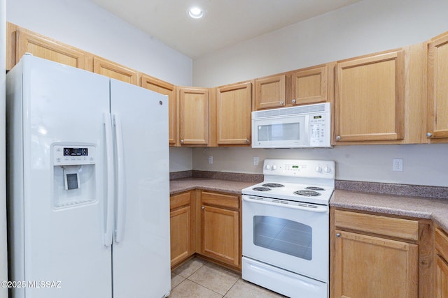 kitchen with light brown cabinetry, white appliances, and light tile patterned flooring