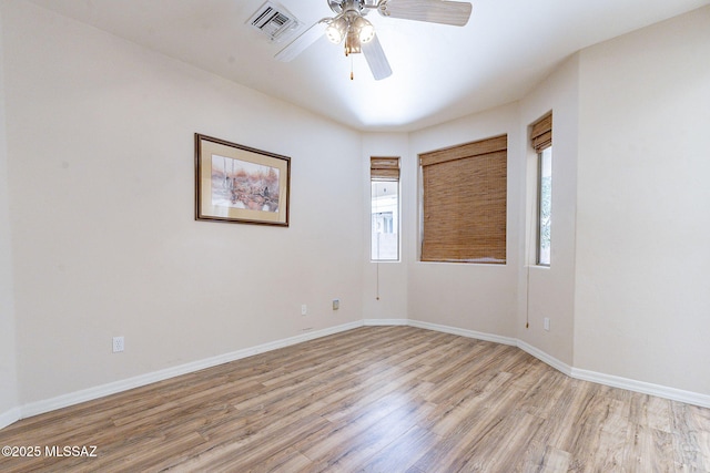 empty room featuring light wood-style floors, visible vents, baseboards, and a ceiling fan