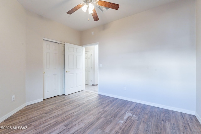 unfurnished bedroom with a closet, baseboards, and wood finished floors