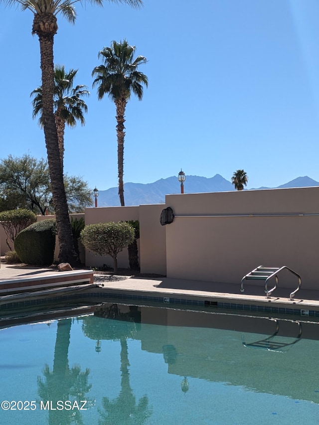 view of swimming pool featuring a fenced in pool and a mountain view