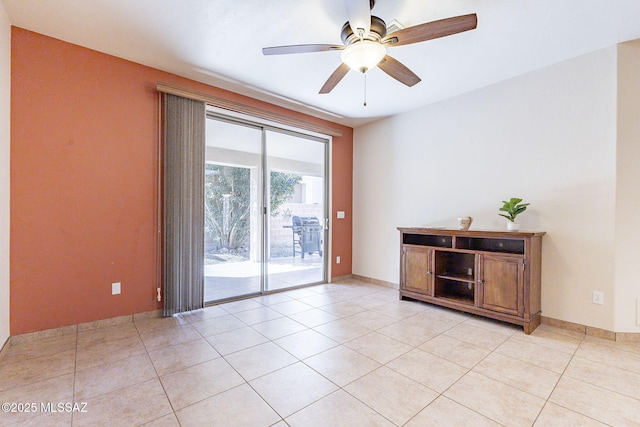 spare room with light tile patterned floors, ceiling fan, and baseboards