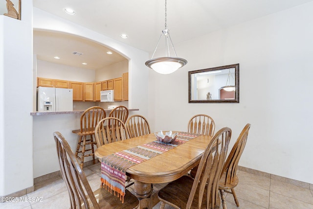 dining space featuring light tile patterned floors, arched walkways, recessed lighting, visible vents, and baseboards